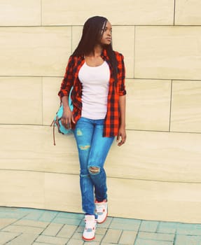 Portrait of young african woman with backpack on the city street