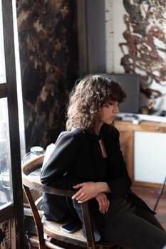 portrait of a young beautiful woman with curly hair in the studio