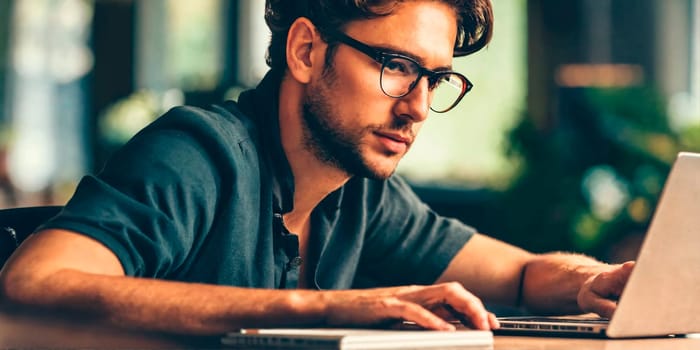 A man with glasses works at a computer in the tropics. Generative AI. High quality photo