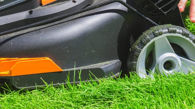 At a residential suburban house, a lush green lawn is meticulously mowed using an electric lawn mower, creating a well-manicured and inviting outdoor space.