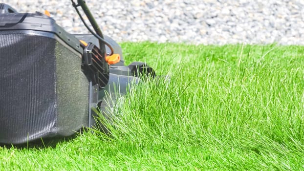 At a residential suburban house, a lush green lawn is meticulously mowed using an electric lawn mower, creating a well-manicured and inviting outdoor space.