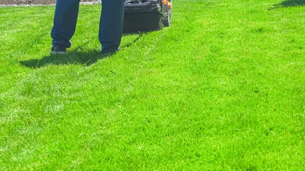 At a residential suburban house, a lush green lawn is meticulously mowed using an electric lawn mower, creating a well-manicured and inviting outdoor space.