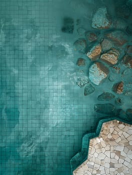 The water in the pool is a stunning electric blue, surrounded by rocks that give it a rocky flooring pattern reminiscent of a road surface