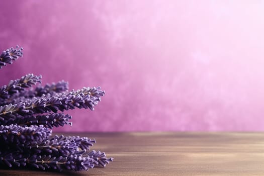 Lavender sprigs on a wooden surface against a pink background.