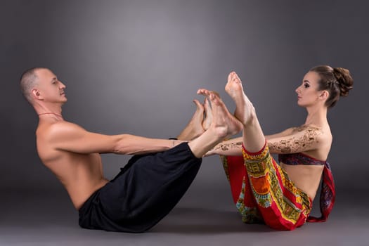 Studio photo of man and woman doing yoga together