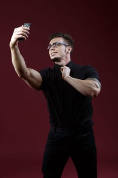 Image of stylish young guy doing selfie in studio