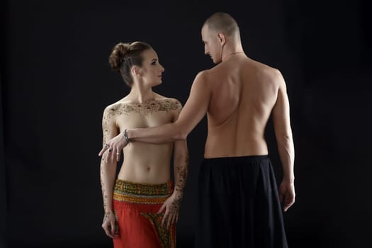 Nude yoga. Photo of man covers woman's breast with his hand