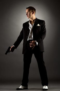 Image of handsome man dressed as gangster holding gun