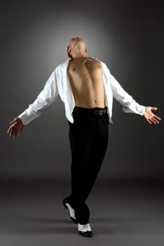 Artistic man dancing. Studio shot, on grey backdrop