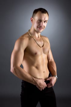Studio portrait of smiling man with naked torso posing at camera