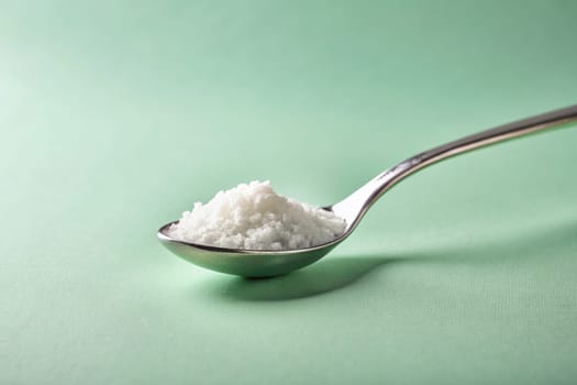 Close up of a spoon full of salt on background. isolated. Food concept.