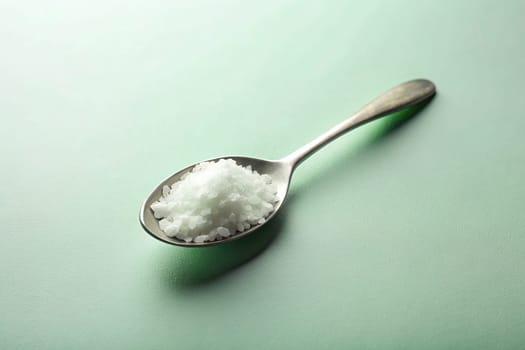 Close up of a spoon full of salt on background. isolated. Food concept.