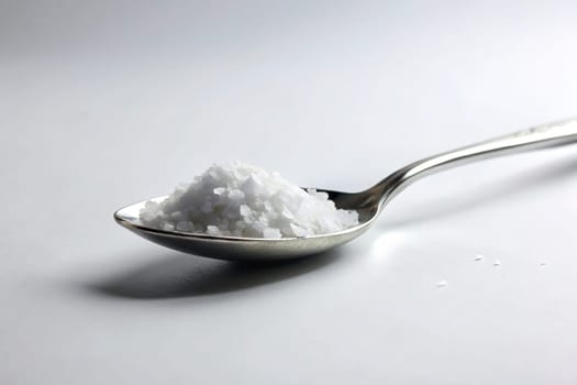 Close up of a spoon full of salt on background. isolated. Food concept.