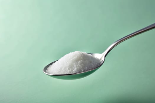 Sugar in a spoon on background, close-up. isolated. Food concept.