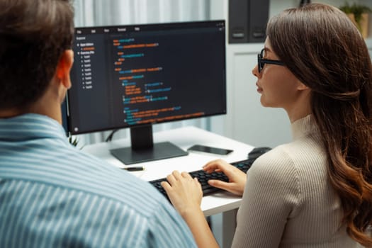 Team skilled developers program coding discussing creative website planning software project on two screen monitor's full stack data analyzing design at office with back side view concept. Postulate.