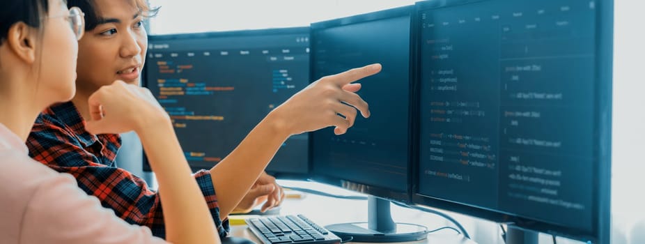 Cropped image of professional programer team collaboration discuss about web coding while coworker point java script displayed on computer at modern company office. Closeup. Burgeoning.