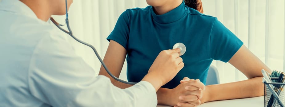 Patient attend doctor's appointment at clinic or hospital office. Doctor examining and diagnosis symptoms while checking the patient's pulse with stethoscope. Panorama Rigid