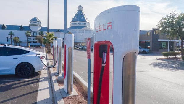 Primm, Nevada, USA-December 3, 2022-During the day, a Tesla vehicle is seen charging at a Tesla Supercharging station, utilizing the high-speed charging infrastructure for convenient and efficient electric vehicle refueling.