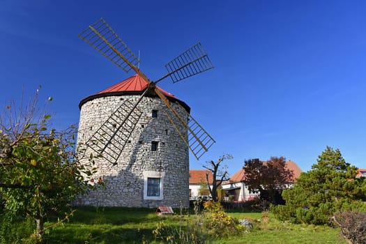 Beautiful old windmill and landscape with the sun. Ostrov u Macochy, Czech Republic. Europe.