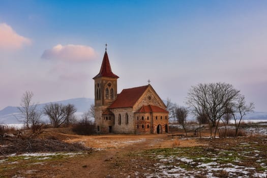 Beautiful old church of St. Linhart. Catholic temple village of Musov - Pasohlavky, Czech Republic. Photo of winter landscape with sunset on a dam New Mills (Nove Mlyny).