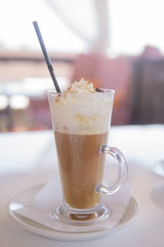 coffee is served in a tall glass glass with a straw. The concept of coffee drinks from the bar menu.