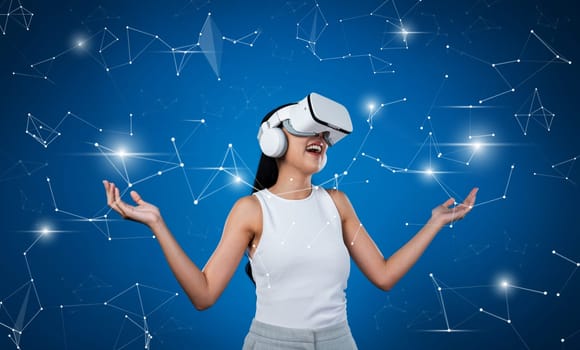 Female stand wear white VR headset and white sleeveless connect metaverse, future technology create cyberspace community. She look around and gesticulate enjoy communicate other users. Hallucination.