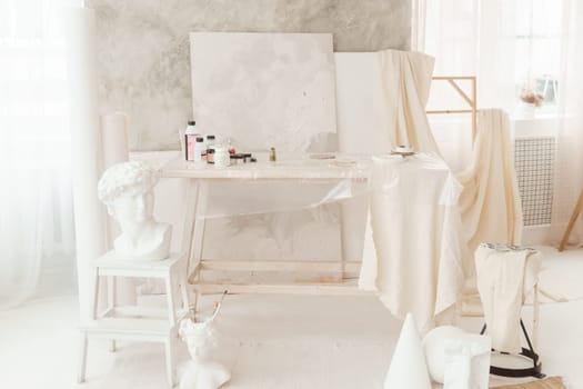 The interior of the art workshop is decorated in bright colors. Working materials of the artist and the sculptor