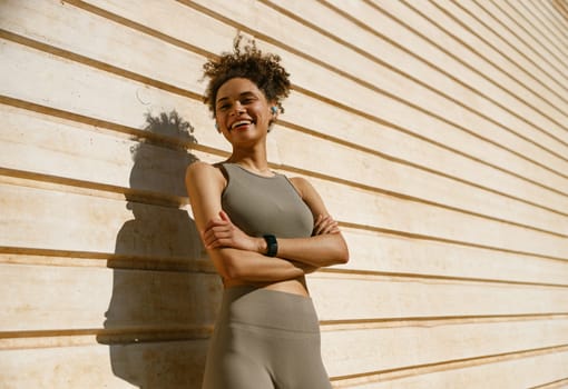 Female athlete in sportswear have a rest after morning jogging outside and looks away