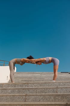 Young sportswomen in tracksuit are stretching outdoor and preparing to jogging. Healthy life concept