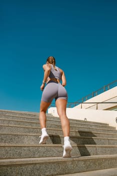 Athletic woman in sportswear is jogging around the city in early morning. Reaching the goal
