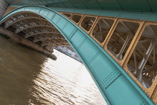 London, UK - Feb 27, 2024 - Detail of Structure and Girders supporting Southwark Bridge Over The River Thames in London. The side of a turquoise cast iron bridge, Curved steel Bridge, Space for text, Selective focus.