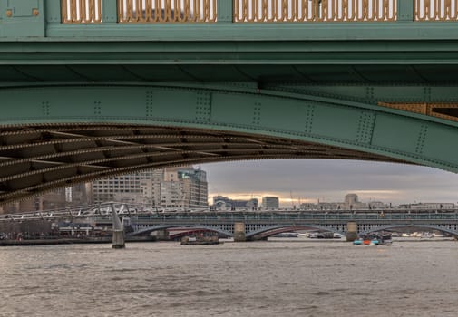 London, UK - Feb 27, 2024 - View of Blackfriars Bridge and Millennium Bridge Looking through underneath Southwark Bridge over The River Thames in London. Space for text, Selective focus.