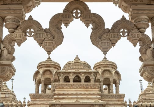 London, UK - Feb 27, 2024 - Entrance archway of The Shree Sanatan Hindu Mandir Hindu Temple (The Shri Sanatan Hindu Temple). Gates of Neasden Temple build from Elaborately carved Jaisalmer limestone, Space for text, Selective focus.