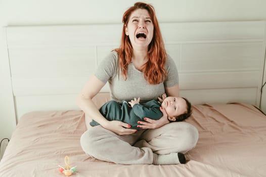 A woman holds a child in her arms and cries. Postpartum depression