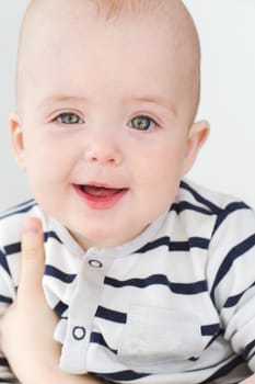 Vertical studio portrait of adorable little boy looking at camera.