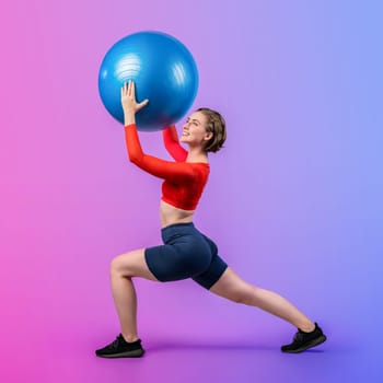 Full body length gaiety shot athletic and sporty young woman with fitness exercising ball in standing posture on isolated background. Healthy active and body care lifestyle.