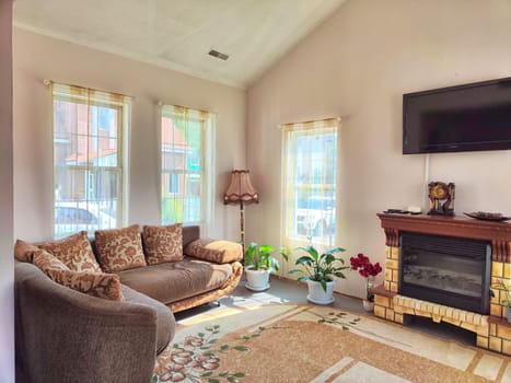 A large cozy room with sofa, armchair, flowers and window. Winter garden with plants in the house. Concept living or hotel room