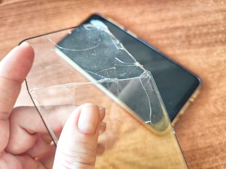 Removing Protective Film From Cracked Screen. Peeling off a cracked screen protector from a phone