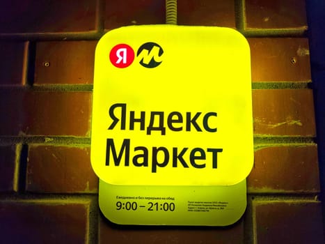 Kirov, Russia - February 06, 2024: Close-up of Yandex Market logo against brick wall. Yandex Market Logo on brick red Background