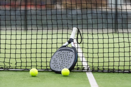 paddle tennis racket and balls on court . High quality photo