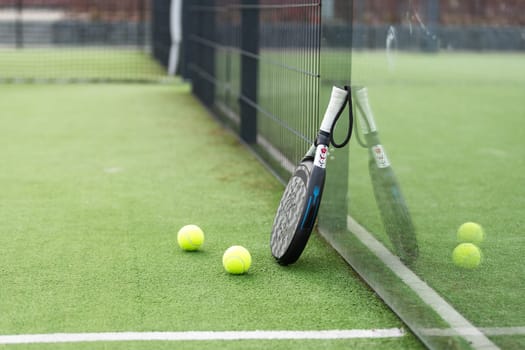 White professional paddle tennis racket with natural lighting on blue background. Horizontal sport theme poster, greeting cards, headers, website and app. High quality photo
