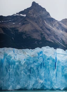 Patagonia's landscape features majestic mountains juxtaposed with icy formations, highlighting nature's vast beauty.