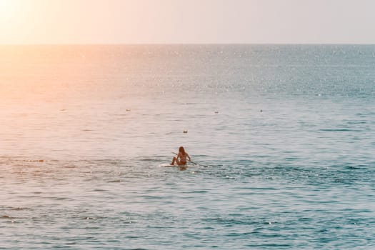 Sea woman sup. A happy positive woman in hat with family relaxing in sea, aerial back view of family on SUP board floating on calm water. Active lifestyle at sea. Summer vacation. Slow motion