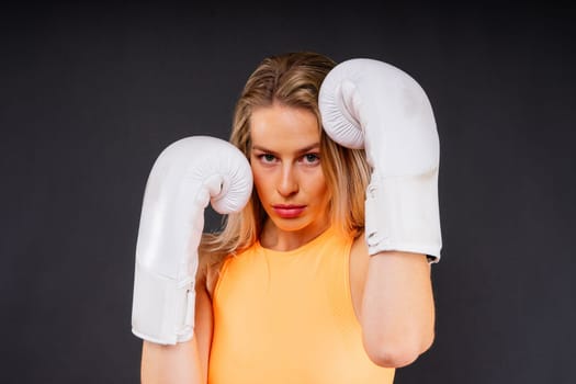 Female boxer hitting at boxing studio. Woman in gloves training hard.