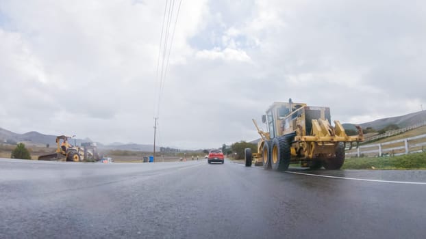 Santa Maria, California, USA-December 6, 2022-Vehicle navigates the streets of Morro Bay, California, during a cloudy winter day. The atmosphere is moody and serene as the overcast sky casts a soft light on the charming buildings and quiet streets of this coastal town.