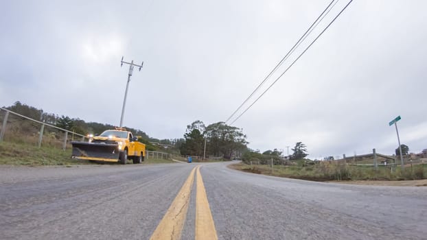 Santa Maria, California, USA-December 6, 2022-Vehicle navigates the streets of Morro Bay, California, during a cloudy winter day. The atmosphere is moody and serene as the overcast sky casts a soft light on the charming buildings and quiet streets of this coastal town.