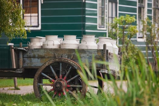 Cart with cans in an ancient village Wormerwer in the evening Netherlands.