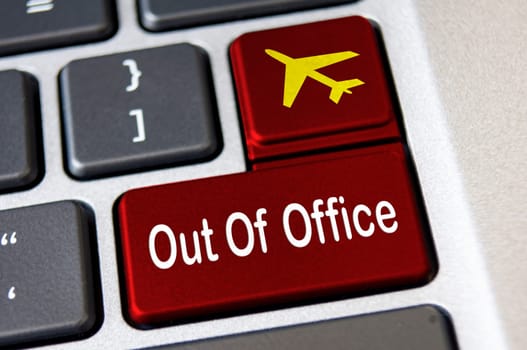 Out of office text on red laptop keyboards. Vacation and holiday concept.