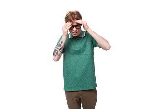 young shocked european red-haired man dressed in a green t-shirt with surprised features.