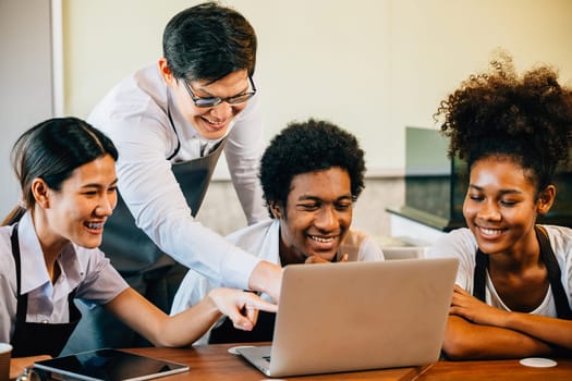 Coffee shop business brings joy fun pride to young entrepreneurs. Planning managing with laptop brings satisfaction. Baristas owners collaborate for success teamwork smiling faces.